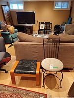 Overall view of chair and foot stool near sofa