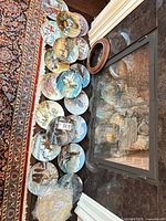 Twelve plates lined by fireplace with wooden frame and bag of hangers