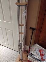 Pair of crutches leaning against wall, showing full length and pads