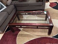 Overall view of coffee table showing glass top and wood frame