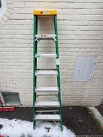 Full front view of green fiberglass step ladder