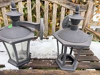 Both metal wall mount lantern lights side by side on bench showing overall condition