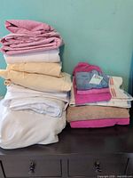 Stack of folded sheets and towels showing quantity and colors