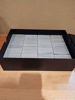open black storage box showing rows of Magic cards