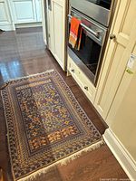 Rug on floor beside cabinetry showing overall size and placement