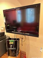 Front view of Sony Bravia 32-inch TV mounted on wall with cables visible