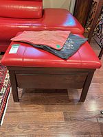 Table with red leather pad and two pillow covers on top