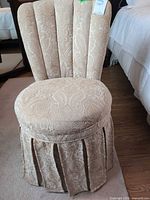 Front view of upholstered vanity chair showing channel back, skirted base
