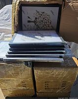 Stack of matte black frames on top of master cartons