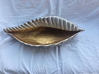 Side view showing ribbed silver exterior and gold interior