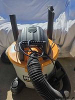 Top view of Ridgid shop vacuum with hose, extension wands and crevice nozzle visible