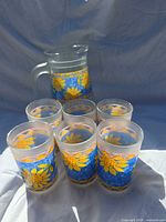 Pitcher behind six tumblers showing pattern