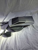 Side view of Cybertruck model on levitation base with cord and adapter visible