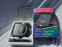 CD player seated in styrofoam next to manual and box
