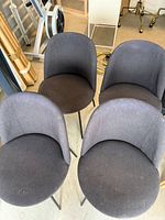 Four dark gray fabric dining chairs viewed from above