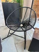 Front view of black Acapulco-style rocking chair