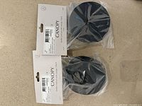 two packaged black metal canopies with cords