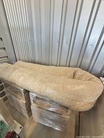 Rolled cream jute rug on pallets