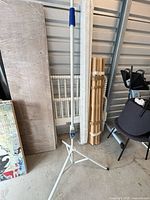 Full view of white metal tripod stand with pole extended, showing three legs and overall structure