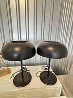 Front view of both black dome table lamps on surface