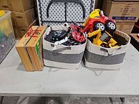 Overall lot showing two storage bins filled with vehicles and two wooden cases
