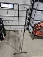 Full view of chrome garment rack showing frame and casters