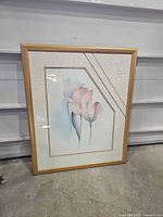 Front view of framed floral print showing artwork, matting, gold frame