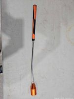 Full view of swing trainer showing grip, angled shaft and orange head