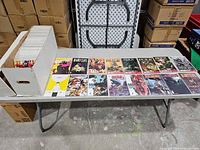 Long white comic storage box partially filled with bagged & boarded comics on table