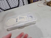 Closed translucent storage case containing mandoline components