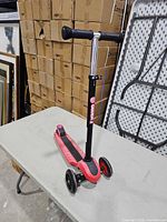 Full view of pink/black Yvolution Glider XL 3-wheel kick scooter on table