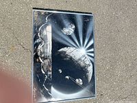 Full view of framed spray paint artwork showing cosmic scene and frame