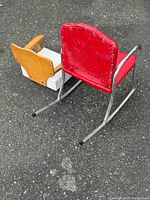 Rear view of both chairs showing red vinyl rocker back and metal runners, side of wooden highchair