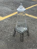 Front view of glass Eiffel Tower dispenser on metal stand