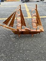 Port side view of bentwood sailboat showing hull, sails, rigging