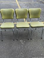Front view of the three matching avocado vinyl chairs on chrome frames
