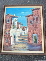 Full view of framed oil painting showing Mediterranean village scene