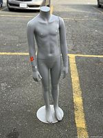 Full front view of grey child mannequin on base