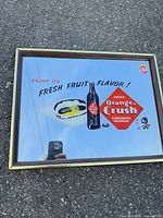 Full view of framed Orange Crush advertising mirror on ground