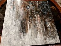 Full view of square abstract painting on glass-top table