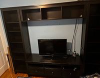Front view of full entertainment unit showing side bookcases, upper cubbies, lower drawers
