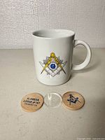 Front view of mug showing Masonic emblem, tokens arranged front