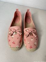 Top view of pair showing floral pattern, bows, tassels, and overall condition