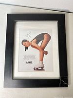 Full view of framed print showing black wood frame and cracked corner