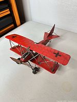 Three-quarter view of red metal WWI biplane model