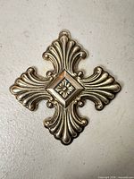 Front view of sterling silver Christmas Cross ornament showing ornate scroll design