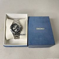 Watch seated on cushion in open Seiko box with separate lid
