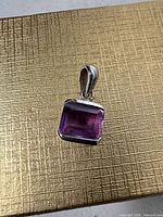Front view of square amethyst pendant in sterling bezel