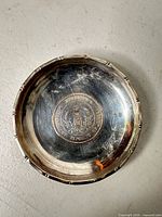 top view of sterling dish showing inlaid coin and rim detail