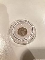 Coin in plastic capsule with label visible